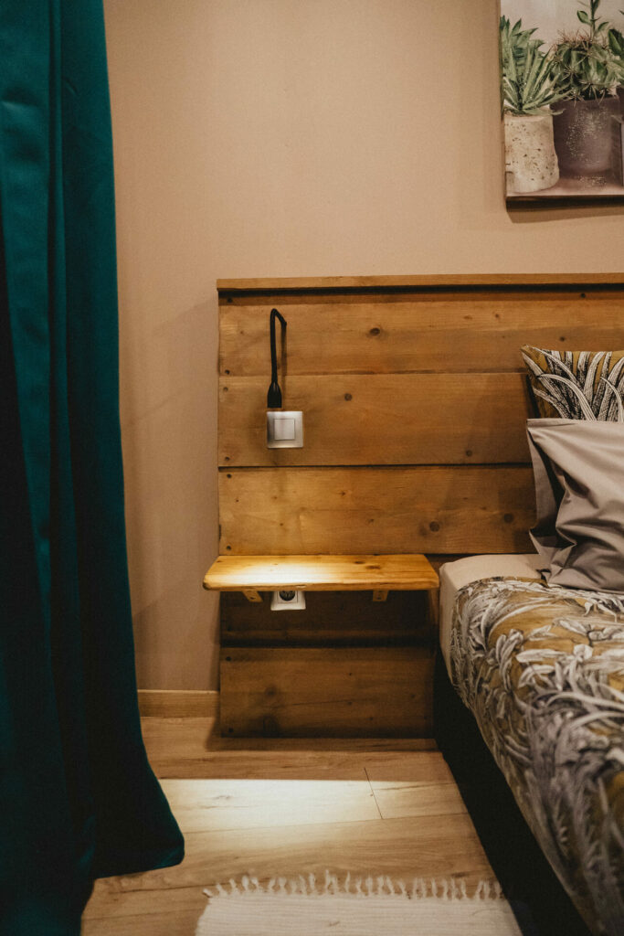 Chevet et liseuse sur tête de lit en bois