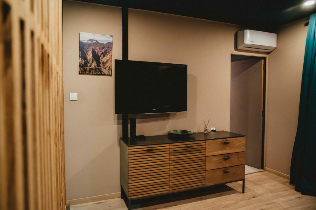 Téléviseur sur commode bois avec climatisation